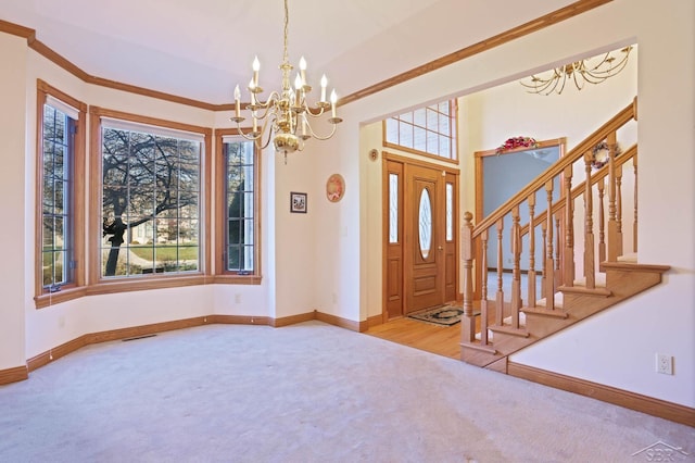 carpeted entryway with an inviting chandelier and ornamental molding