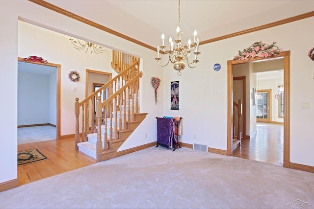 spare room featuring wood-type flooring, ornamental molding, and an inviting chandelier