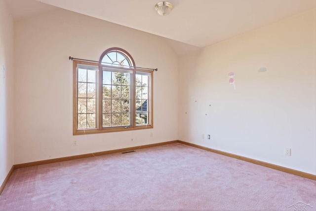 carpeted spare room with lofted ceiling