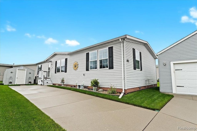 view of front of house featuring a garage, a front lawn, and a storage shed