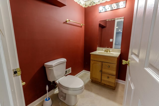 half bathroom featuring vanity, toilet, visible vents, and baseboards