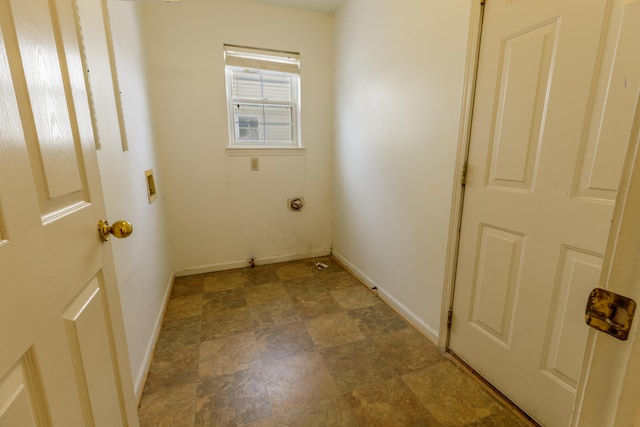 laundry area with laundry area, stone finish floor, baseboards, and electric dryer hookup