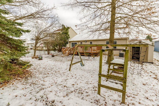 view of playground featuring an outbuilding, a storage unit, and a wooden deck