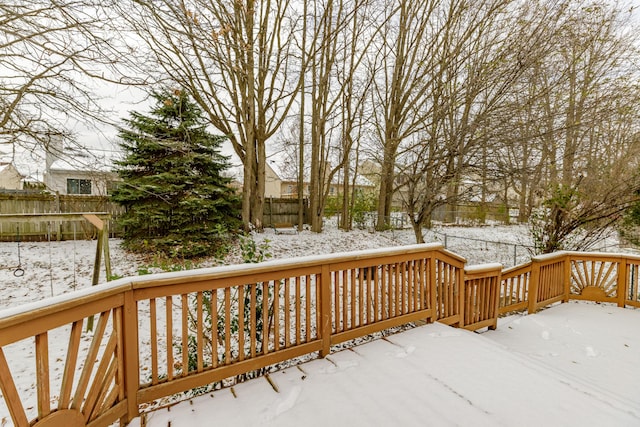 snow covered deck featuring a fenced backyard