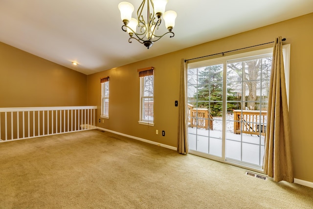 unfurnished room with visible vents, lofted ceiling, carpet, an inviting chandelier, and baseboards