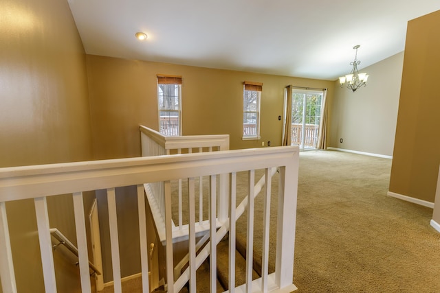 stairs featuring carpet flooring, baseboards, and an inviting chandelier