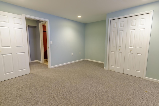 unfurnished bedroom with a closet, recessed lighting, baseboards, and carpet floors