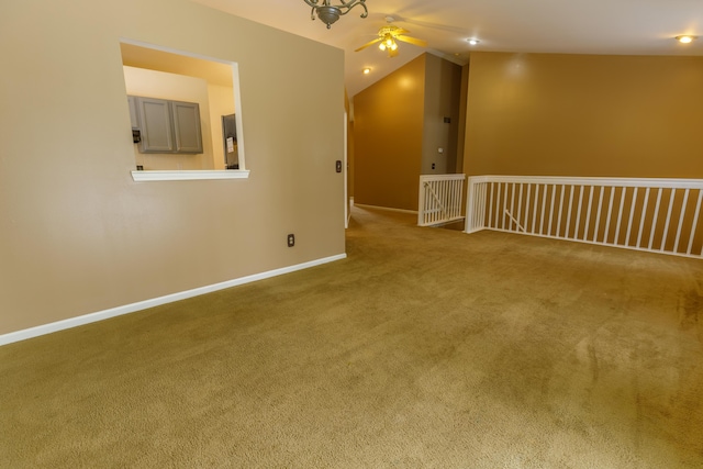 spare room with baseboards, lofted ceiling, a ceiling fan, and carpet flooring