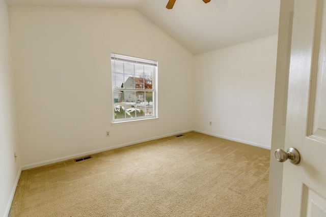 unfurnished room with visible vents, lofted ceiling, carpet floors, baseboards, and ceiling fan