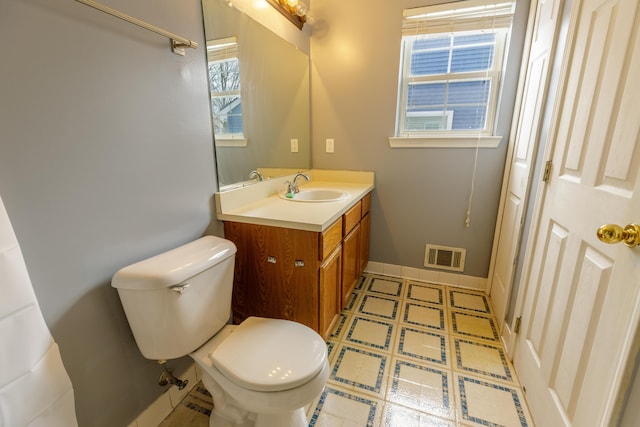 bathroom with visible vents, baseboards, toilet, tile patterned floors, and vanity