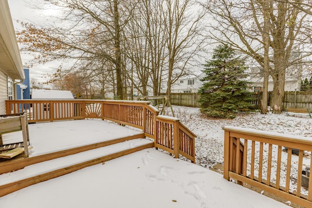 snow covered deck featuring an outdoor structure and a fenced backyard