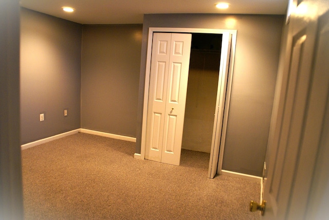 unfurnished bedroom with recessed lighting, a closet, baseboards, and carpet