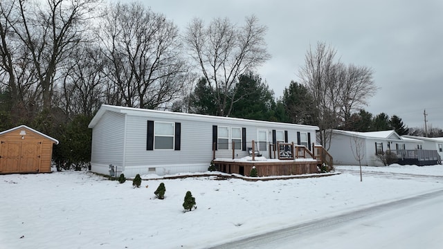 manufactured / mobile home featuring a deck and a storage shed