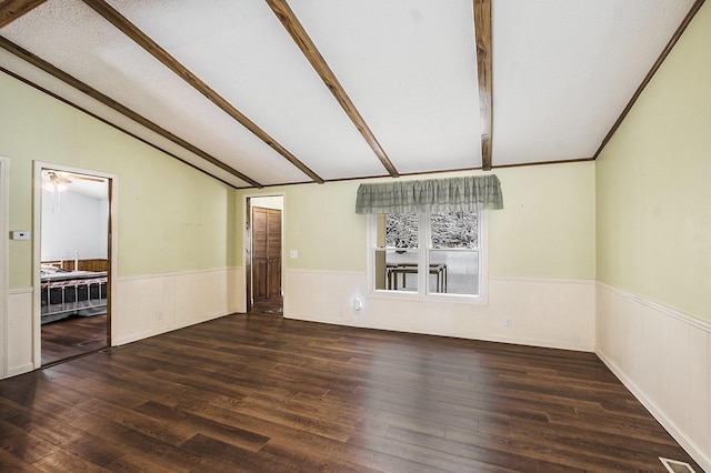 unfurnished room featuring dark hardwood / wood-style flooring, vaulted ceiling with beams, and a textured ceiling