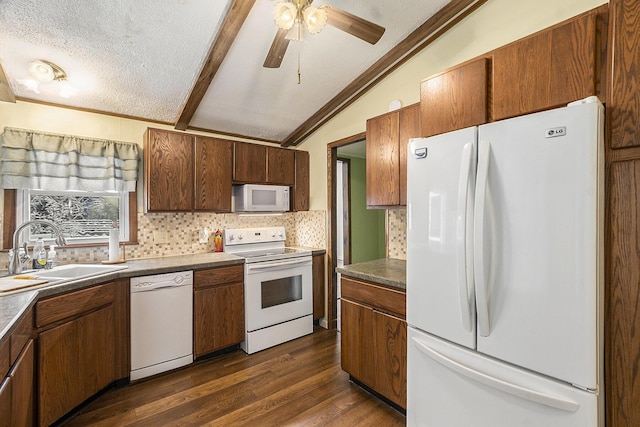 kitchen featuring lofted ceiling, white appliances, dark wood-type flooring, sink, and a textured ceiling