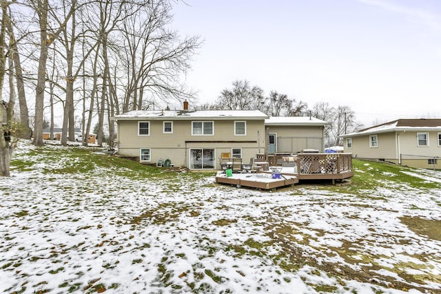 snow covered rear of property with a wooden deck