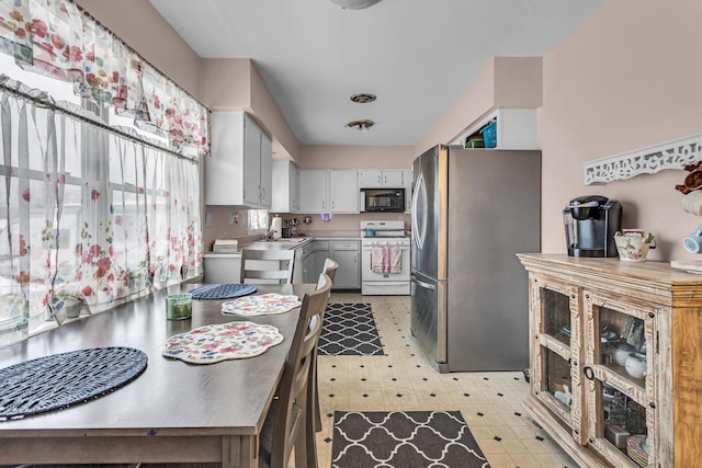 kitchen featuring white stove and stainless steel refrigerator