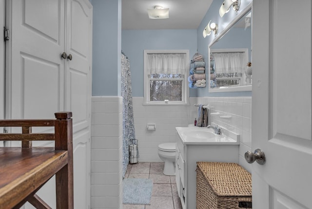 bathroom featuring tile patterned flooring, vanity, toilet, and tile walls