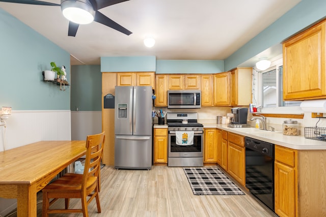 kitchen featuring light wood-type flooring, stainless steel appliances, ceiling fan, and sink