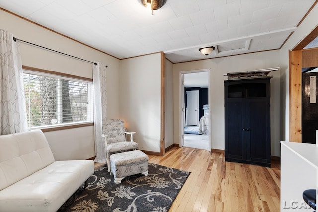 living area with light hardwood / wood-style flooring and ornamental molding