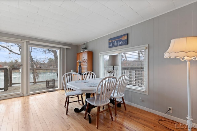 dining area featuring wood-type flooring and a water view