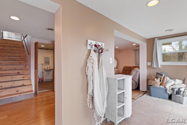 interior space with a textured ceiling and light hardwood / wood-style floors