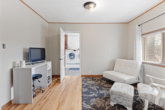 office space with light wood-type flooring, separate washer and dryer, and ornamental molding