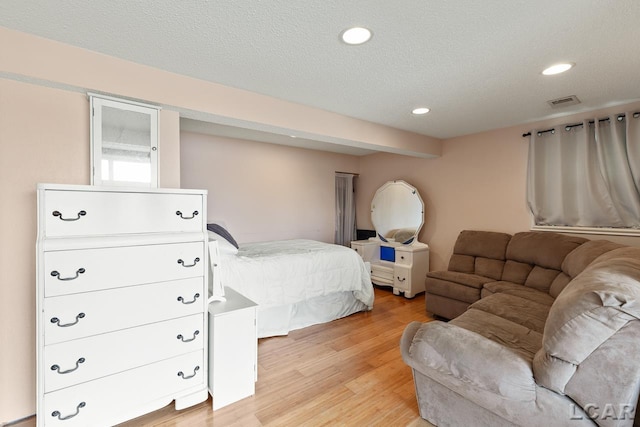 bedroom featuring light wood-type flooring and a textured ceiling