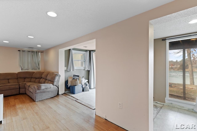 living room featuring light hardwood / wood-style flooring and a textured ceiling