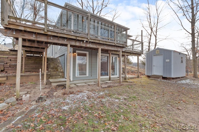 rear view of property with a deck and a storage unit