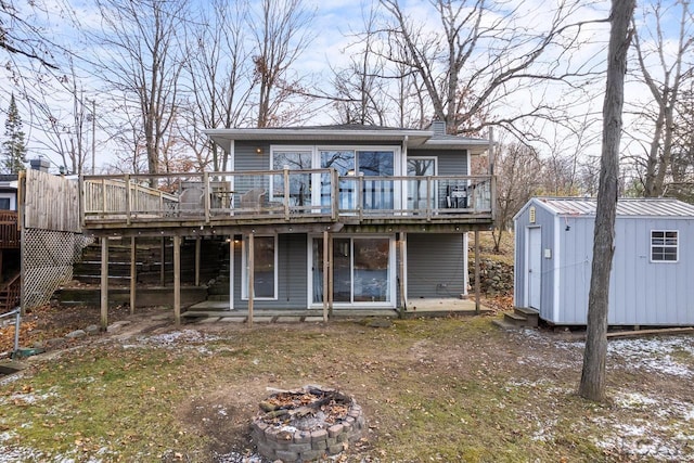 exterior space featuring a fire pit, a storage shed, and a wooden deck