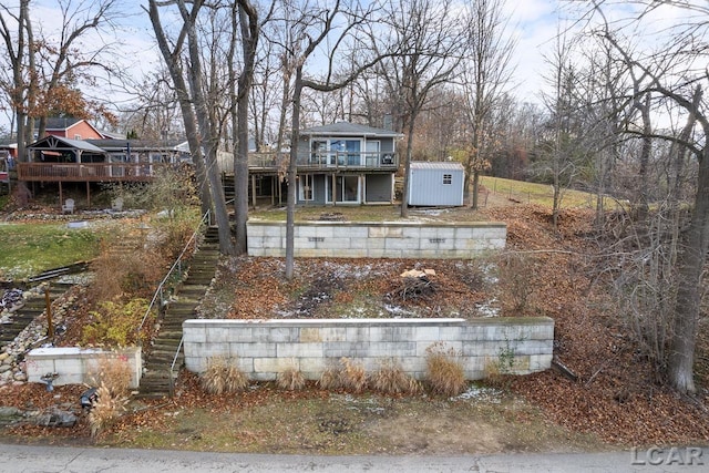 view of front of property with a storage shed and a wooden deck