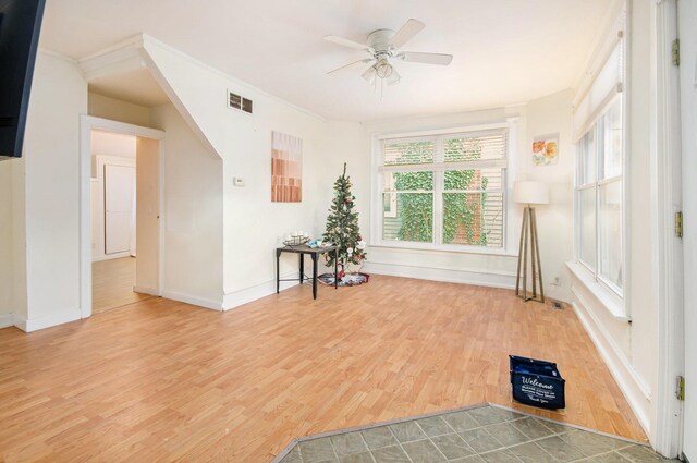 interior space featuring ceiling fan, ornamental molding, and hardwood / wood-style flooring