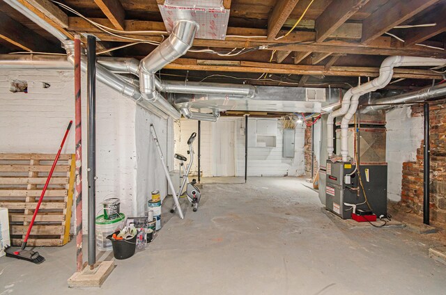 basement featuring electric panel and heating unit