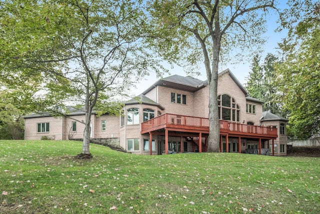 rear view of property featuring a lawn and a wooden deck