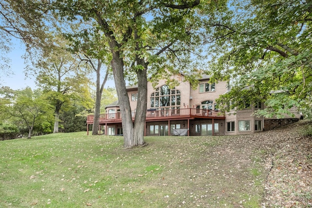 rear view of house featuring a wooden deck and a lawn