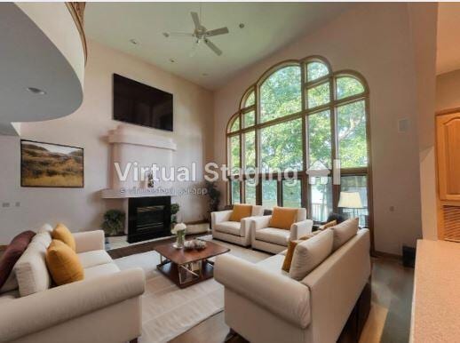 living room with ceiling fan, a fireplace, and high vaulted ceiling