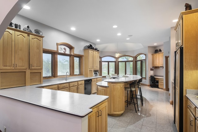 kitchen featuring a kitchen bar, kitchen peninsula, refrigerator, a chandelier, and a center island