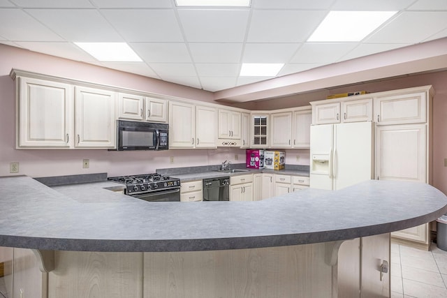 kitchen with black appliances, kitchen peninsula, and a breakfast bar area