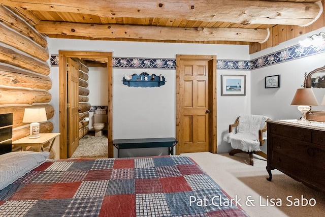 carpeted bedroom with ensuite bath, log walls, beamed ceiling, and wood ceiling