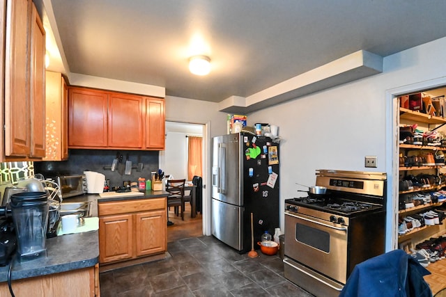 kitchen featuring backsplash, stainless steel appliances, and dark tile patterned flooring