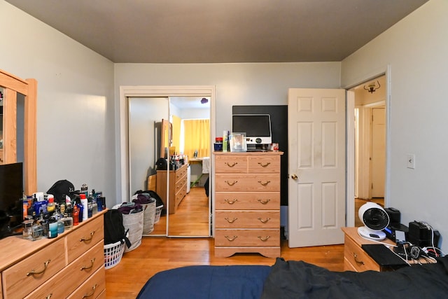 bedroom with light hardwood / wood-style floors and a closet