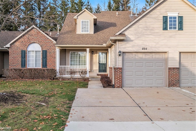 view of front of house featuring a porch, a garage, and a front yard