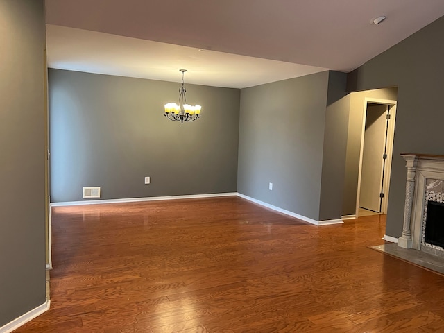 unfurnished living room with dark hardwood / wood-style flooring and a notable chandelier