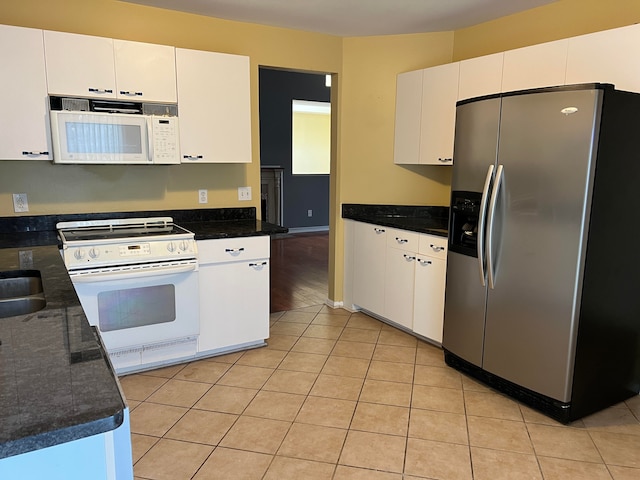 kitchen featuring white cabinetry, white appliances, dark stone counters, and light hardwood / wood-style flooring