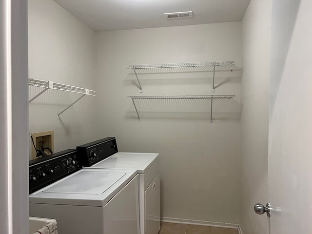 laundry area featuring light tile patterned floors and washing machine and clothes dryer