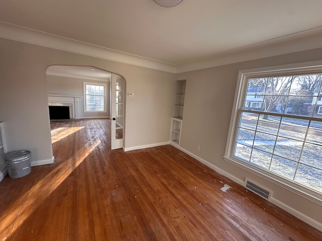 unfurnished living room featuring crown molding and dark hardwood / wood-style flooring