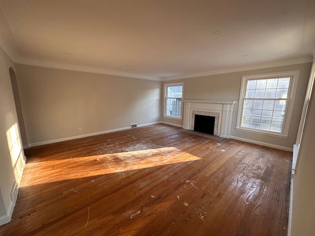 unfurnished living room featuring crown molding, a fireplace, a healthy amount of sunlight, and wood-type flooring