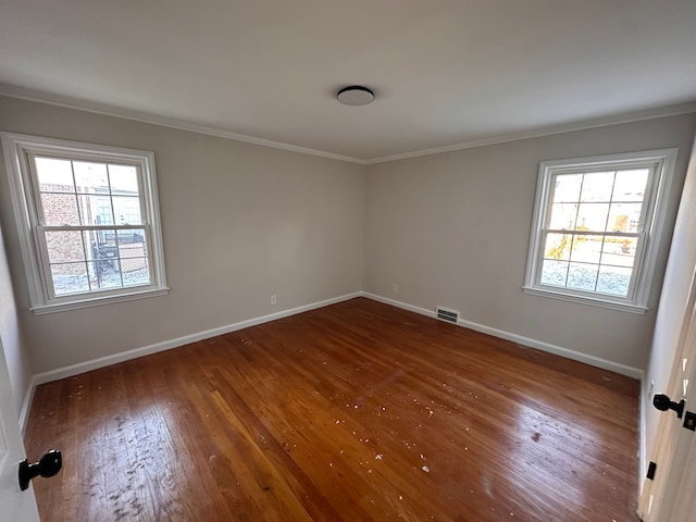 empty room featuring dark hardwood / wood-style flooring and ornamental molding