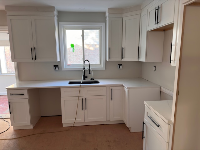 kitchen with white cabinets, sink, and a wealth of natural light